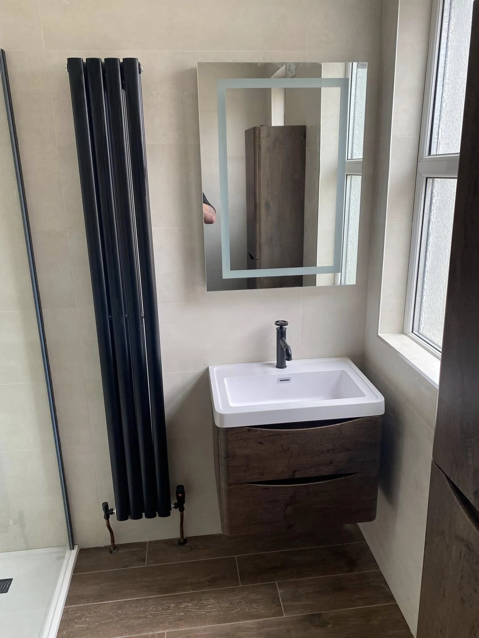 Bathroom sink with black radiator and mirror