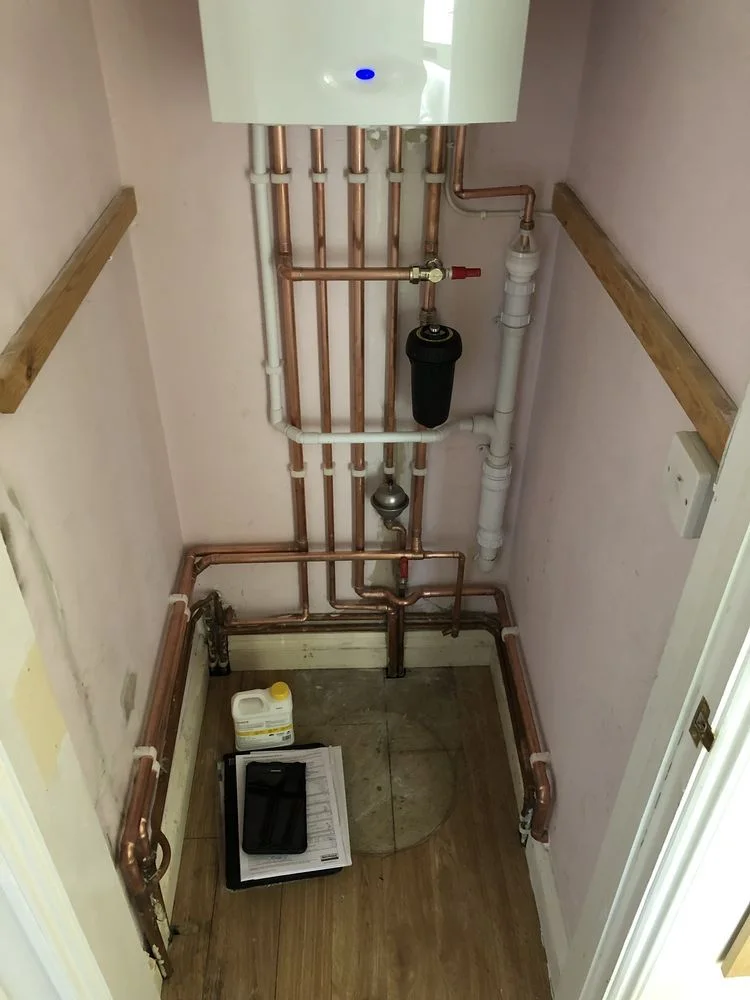 Boiler and copper pipework fitted inside a cupboard by Scott Plumbing and Heating