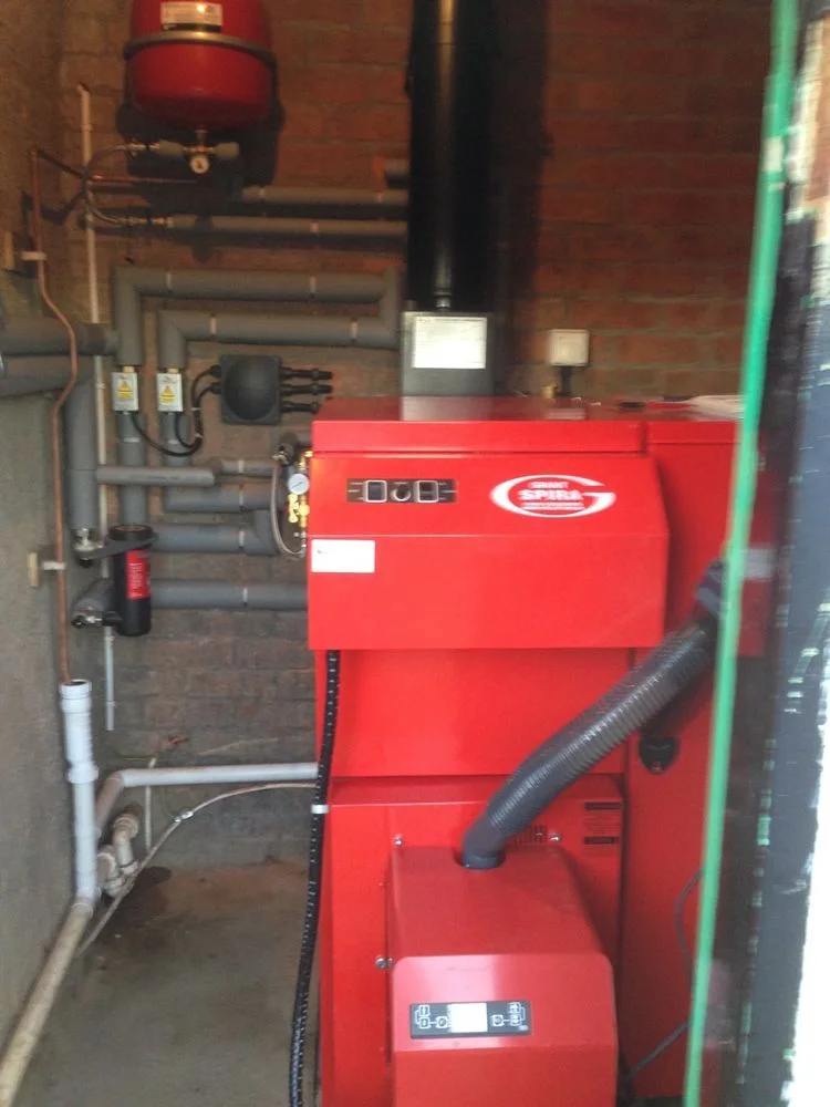 Red heating unit with insulated pipework by Scott Plumbing and Heating